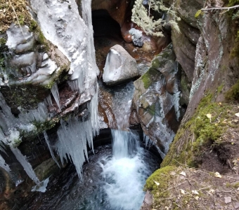 Icicles and flowing water in the narrow rock gorge at Little Hawaii in Bear Creek near Telluride, Colorado