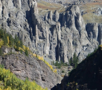Rugged cliff band near Bear Creek Falls with autumn aspens near Telluride, Colorado