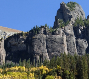 Dramatic rock cliffs in Bear Creek Canyon with autumn aspens near Telluride, Colorado