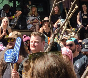 Camp Alderwild stick tournament crowd with a large branching stick and Richard Finger foam finger in Telluride