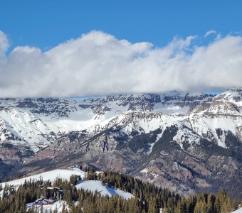 View from the Gold Hill ridgeline across Telluride Ski Resort toward the San Juan Mountains, with the Lift 9 and Lift 6 top terminals visible below.
