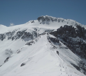 Skiers hiking the snow-covered Gold Hill ridge toward Telluride’s Gold Hill chutes.