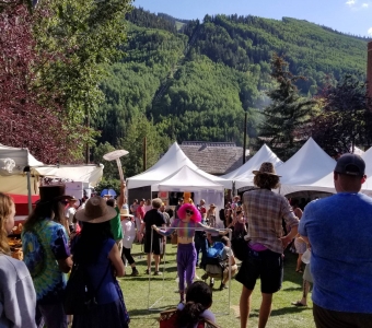 Telluride Mushroom Festival gathering in Elks Park with festival tents and the ski area above town.
