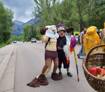 Costumed participants pose during the Telluride Mushroom Festival parade with a basket of Amanita mushrooms