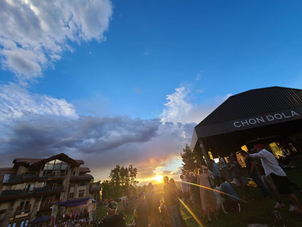 Sunset over the crowd during Easy Jim's concert at Sunset Plaza in Mountain Village