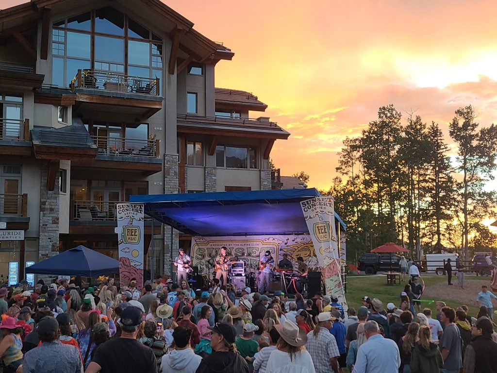 Easy Jim performing onstage at the Mountain Village Sunset Concert Series with the crowd at Sunset Plaza