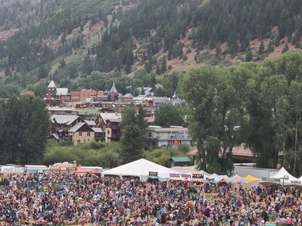 Camp Alderwild 2026 crowd in Telluride Town Park with downtown Telluride and the surrounding mountains beyond