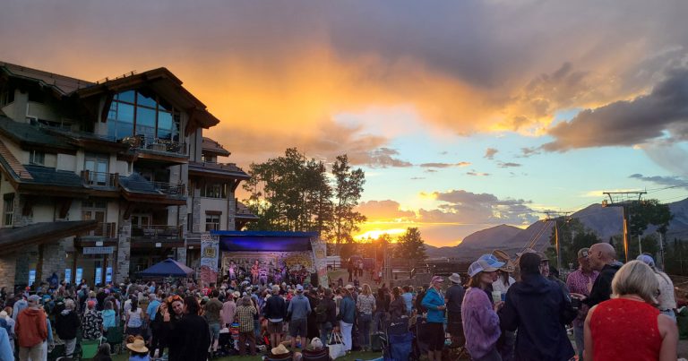 Easy Jim performing at the Mountain Village Sunset Concert Series as the sun sets over the crowd at Sunset Plaza